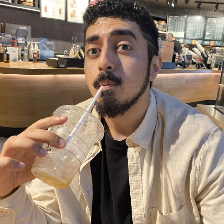 Tyceno sipping an iced drink in a café