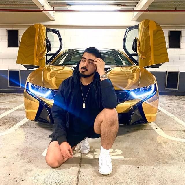 Tyceno crouching in front of a BMW i8 with its doors open